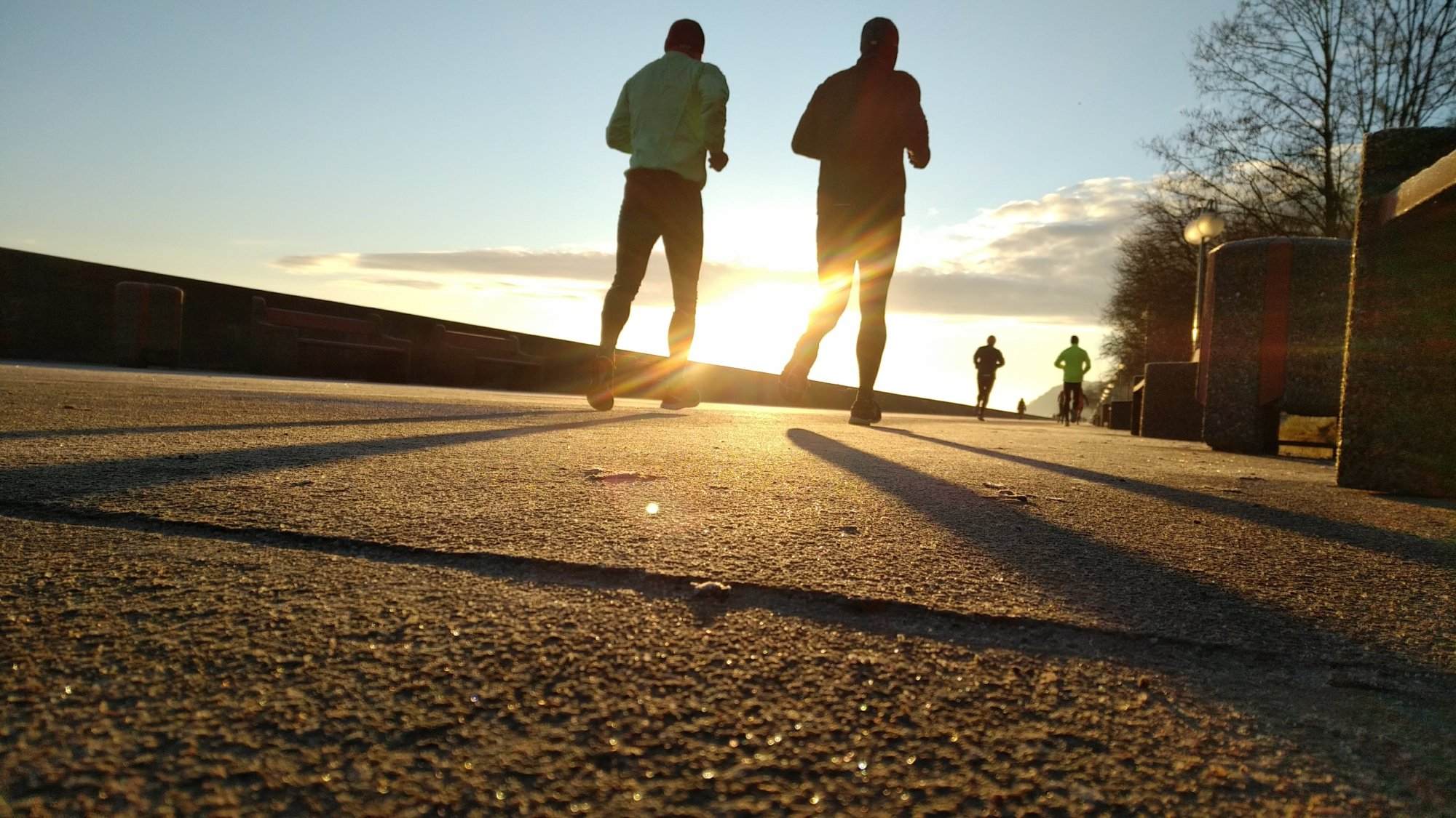 Two people running on a flat course at sunset in the United States.