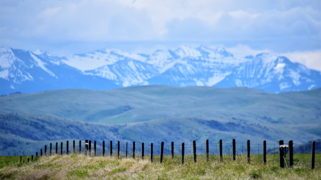 A fence with mountains in the background.