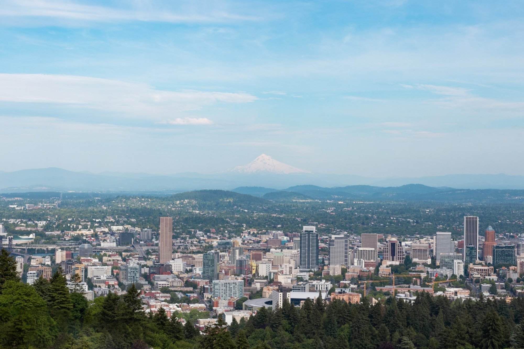 A view of the city of portland with mt hood in the background.
