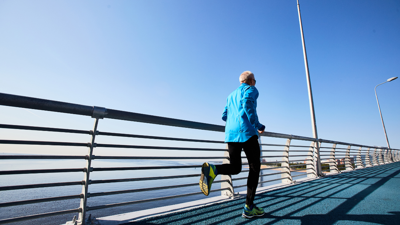 A man is engaging in endurance training on a bridge near the ocean to achieve peak performance.