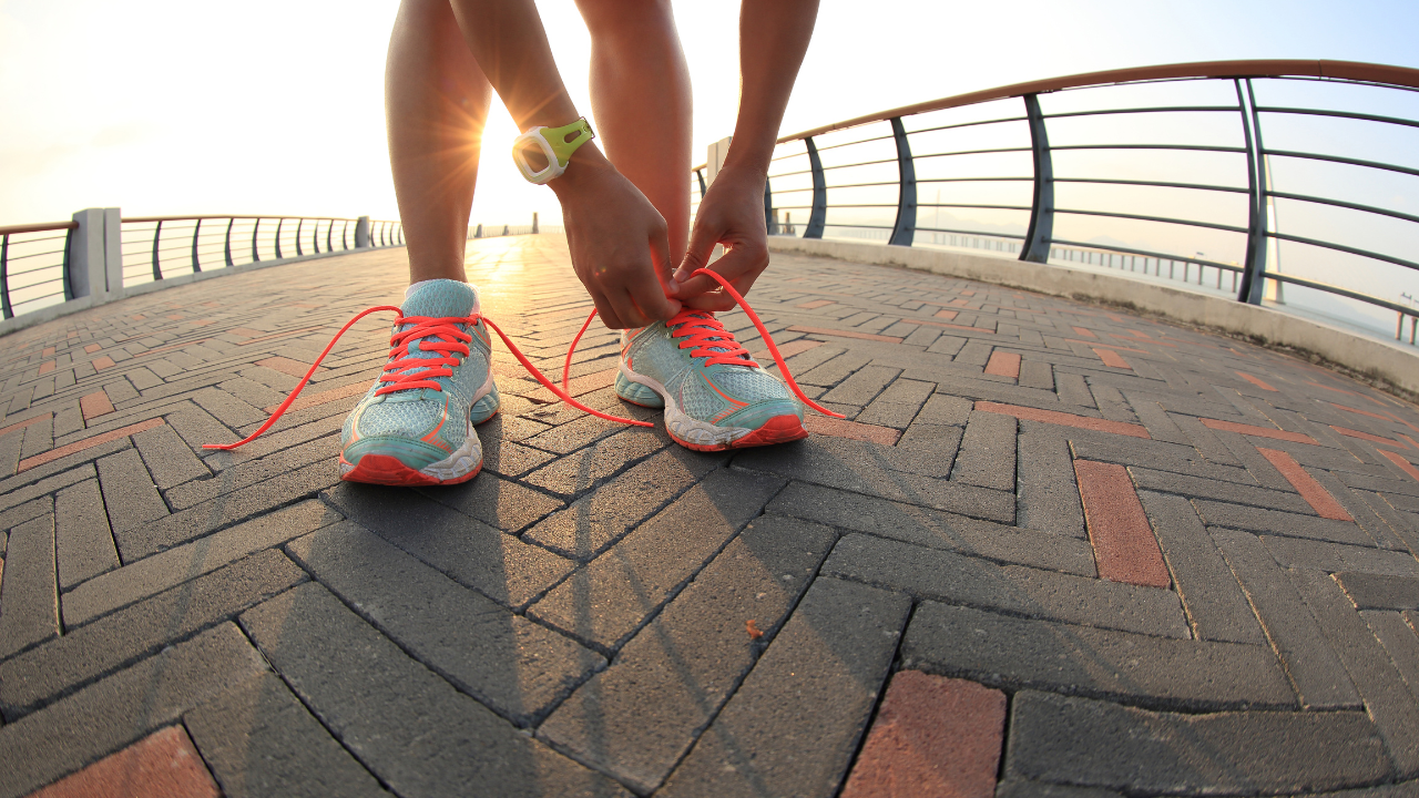 New runners can benefit from these top 5 tips while tying their shoes on a brick walkway.