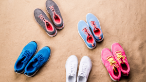 A group of fit running shoes on a sand surface.